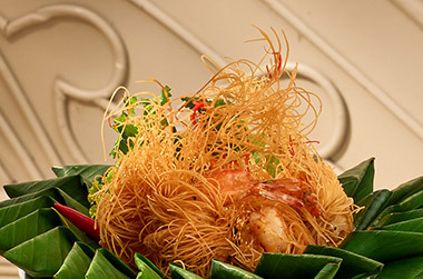 Crispy fried shrimp with golden noodles and herbs