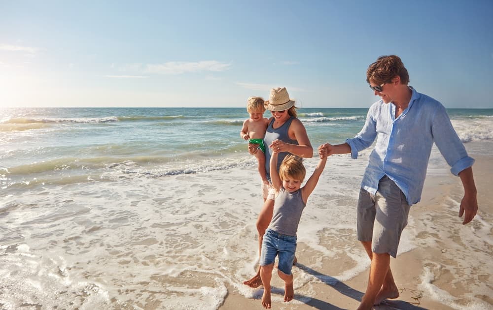 A family with young kids having fun on the beach 